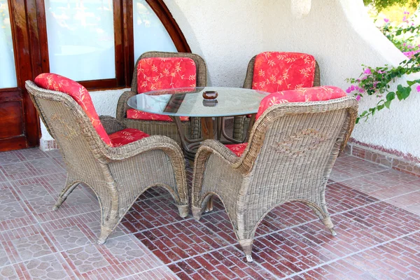 Korbstuhl und Tisch im Freien — Stockfoto