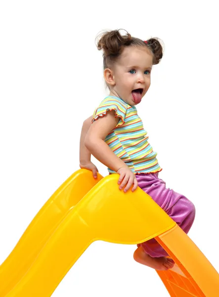 Menina bonito no slide amarelo — Fotografia de Stock