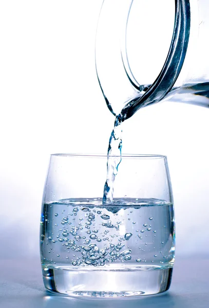 Glas met water en kruik — Stockfoto