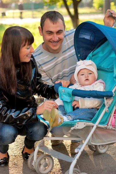 Happy family outdoor with carriage — Stock Photo, Image
