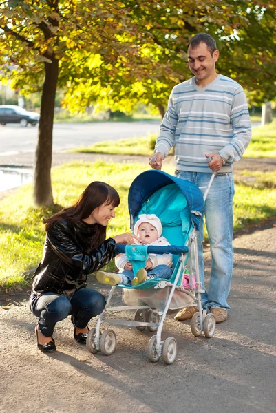 Happy family outdoor with carriage — Stock Photo, Image