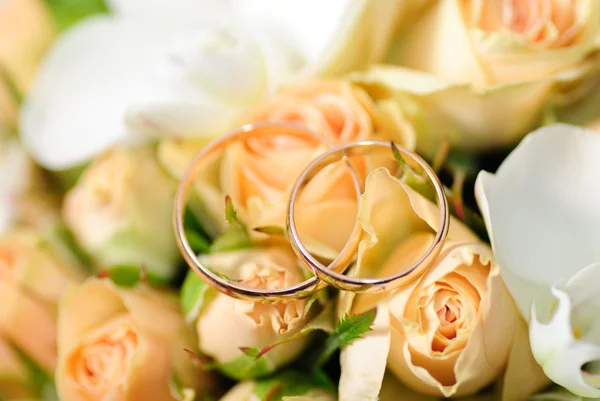 Złote pierścienie na bukiecie róż — Zdjęcie stockowe