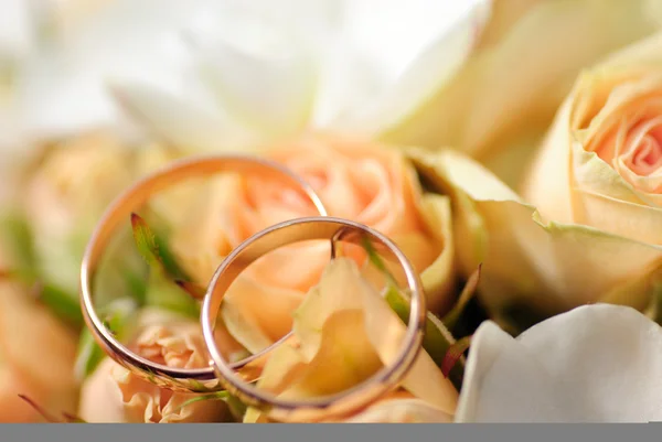 Złote pierścienie na bukiecie róż — Zdjęcie stockowe