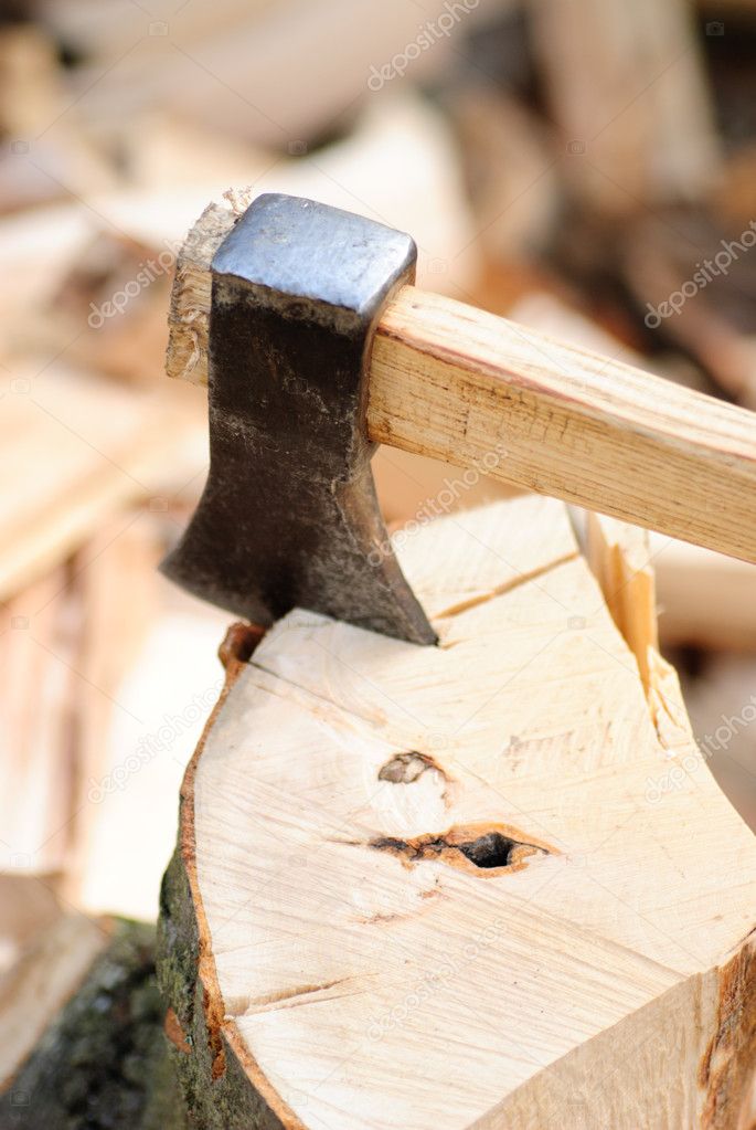 Firewood with axe and male hand. Stocking the fuel.