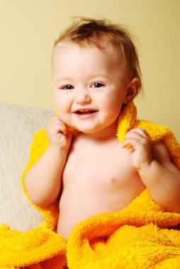 Girl after bathing, sitting in yellow bathrobe clipart