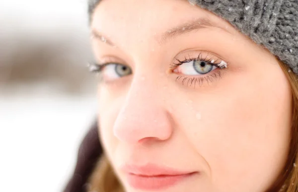 Girl's gezicht met sneeuw buitenshuis — Stockfoto