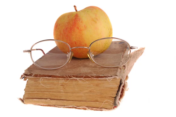 Яблоко и очки на книге — стоковое фото