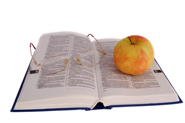 Apple en bril op het boek — Stockfoto