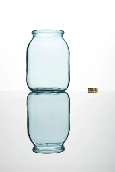 Moedas e frasco de vidro vazio — Fotografia de Stock