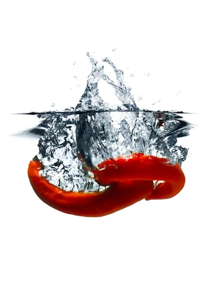 Красный острый перец чили упал в воду — стоковое фото