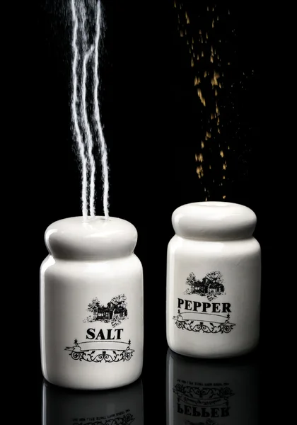 Salt an pepper shakers pouring up — Stock Photo, Image