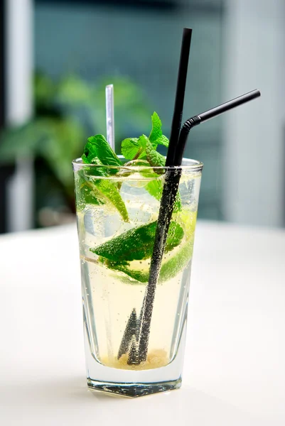 Glass of mojito cocktail with a background of interior cafe — Stock Photo, Image