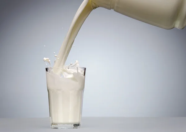 Hälla ett glas mjölk med stänk — Stockfoto