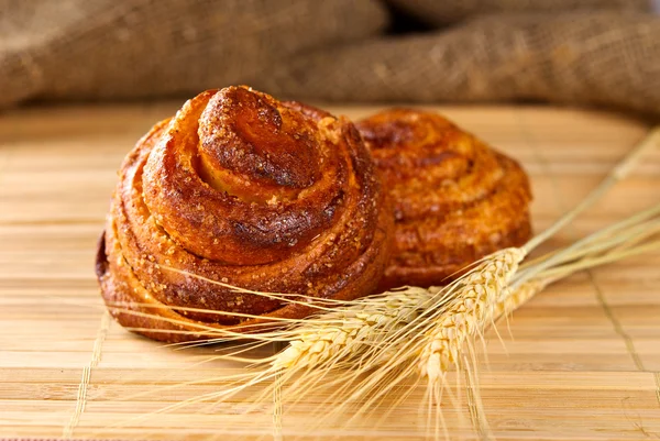 Cinnamon rolls with ear of wheat — Stock Photo, Image