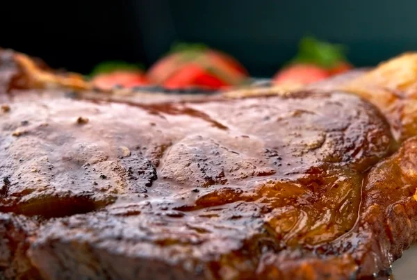 토마토와 함께 흰색 접시에 구운된 고기 갈비뼈의 매크로 스톡 사진