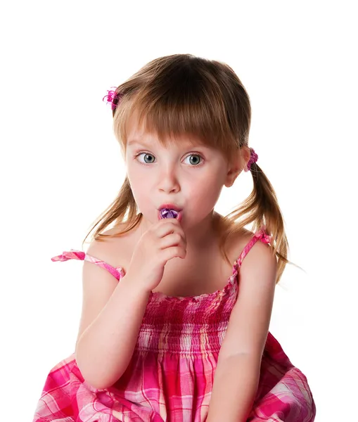 Красивая маленькая девочка с лиловым леденцом — стоковое фото