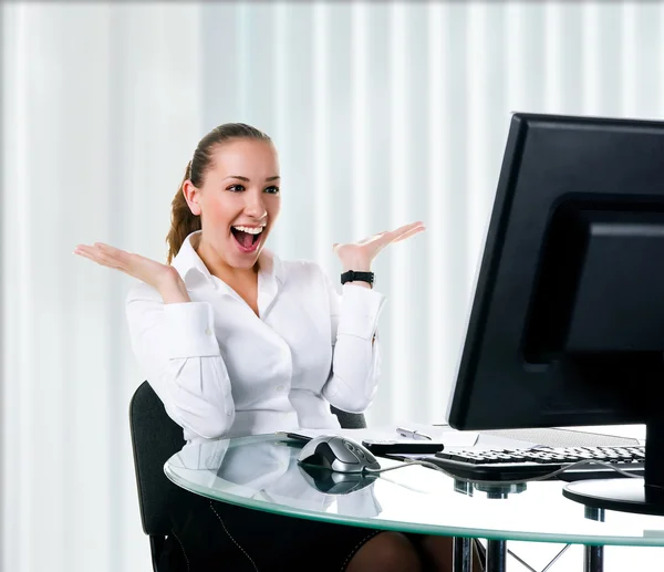 Szczęśliwa kobieta siedzi przy komputerze — Zdjęcie stockowe