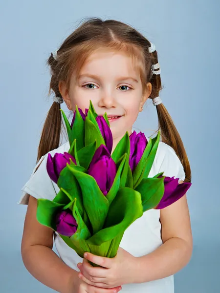 Niedliches kleines Mädchen gibt Tulpen — Stockfoto