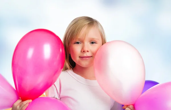 Красивая маленькая девочка с воздушными шарами — стоковое фото