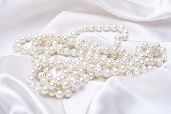 Jewels on white satin — Stock Photo, Image