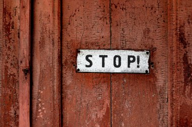 Close up of a sign saying ''stop''on the grunge wooden background clipart