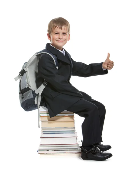 Schoolboy sitting on books — Stock Photo, Image