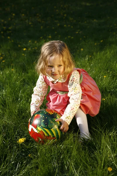 Schattig klein meisje spelen met een bal — Stockfoto