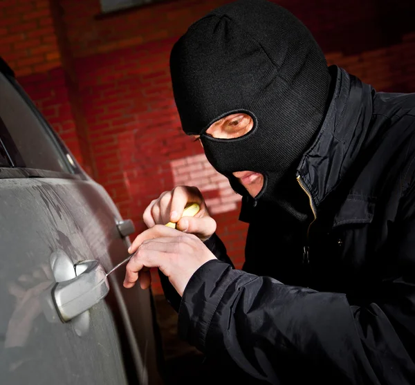 強盗とマスクの泥棒は、車をハイジャックします。 — ストック写真