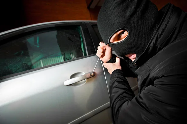 Rånaren och tjuven i en mask kapar bilen — Stockfoto