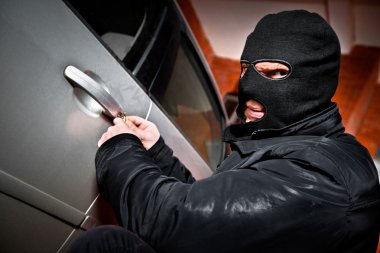 Robber and the thief in a mask hijacks the car clipart