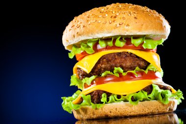 koyu mavi zemin üzerine lezzetli ve iştah açıcı hamburger