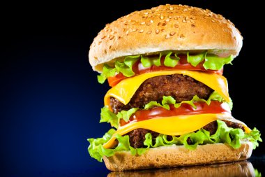 Tasty and appetizing hamburger on a dark blue background clipart