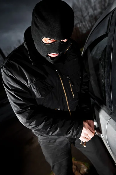 強盗とマスクの泥棒は、車をハイジャックします。 — ストック写真