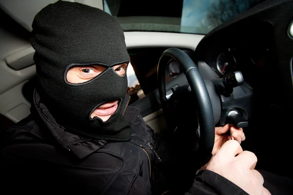 O ladrão e o ladrão com uma máscara sequestram o carro — Fotografia de Stock