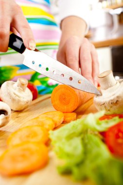 Woman's hands cutting vegetables clipart