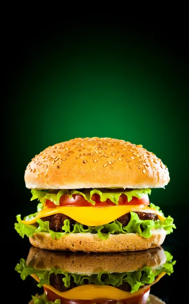 暗く緑の背景に 食欲をそそるおいしいハンバーガー — ストック写真