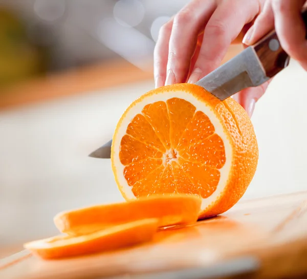 Női kéz vágás narancs — Stock Fotó
