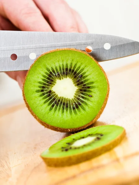 Las manos de la mujer cortando kiwi —  Fotos de Stock