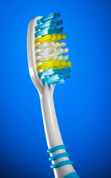 Escova de dentes em um fundo azul escuro — Fotografia de Stock