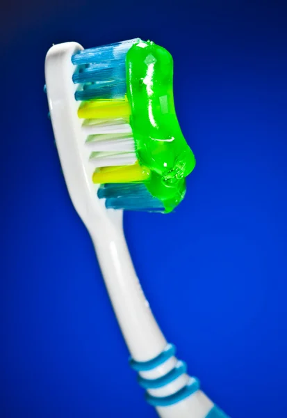 Οδοντόβουρτσα σε σκούρο μπλε φόντο — Φωτογραφία Αρχείου