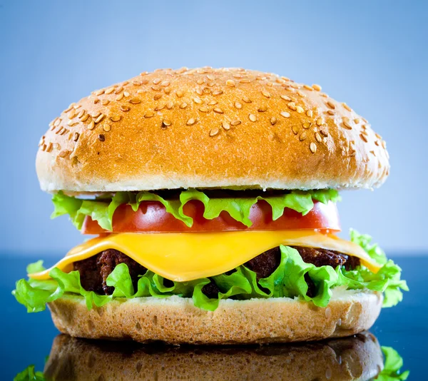Smakelijke Smakelijk Hamburger Een Blauwe Achtergrond — Stockfoto