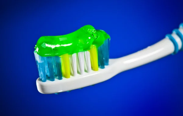 Οδοντόβουρτσα σε σκούρο μπλε φόντο — Φωτογραφία Αρχείου