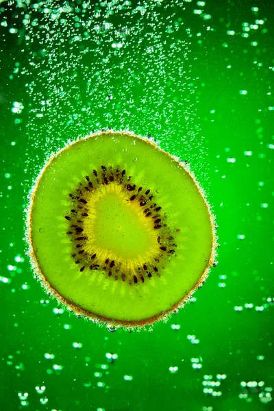Verse Kiwi Valt Het Water Een Groene Achtergrond — Stockfoto