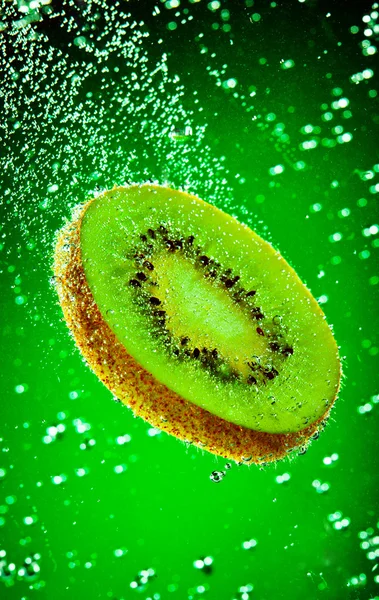 Čerstvé Kiwi Spadá Vodě Zeleném Pozadí — Stock fotografie
