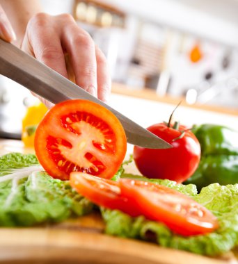 Woman's hands cutting vegetables clipart