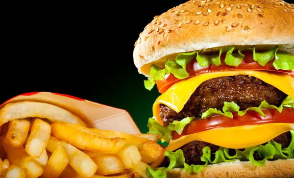 Вкусный гамбургер и картошка фри в темноте — стоковое фото