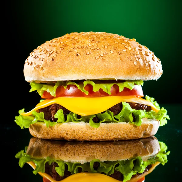 Hamburguesa sabrosa y apetitosa en un verde oscuro — Foto de Stock