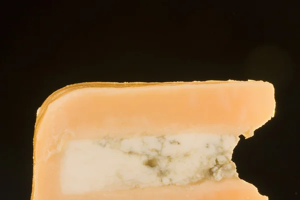 告士打道与黑色背景上的蓝色的奶酪片奶酪 — 图库照片
