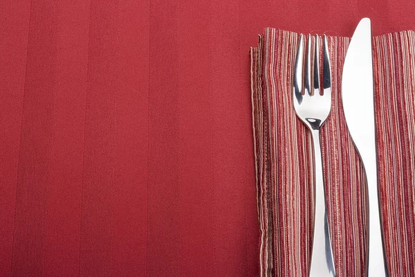 刀和叉作为一餐室任职在餐巾上 — 图库照片