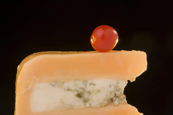 告士打道芝士番茄黑色背景上的蓝色的奶酪片 — 图库照片